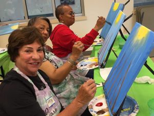 Seniors painting on canvas at St. Louis Oasis