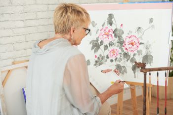 Woman painting flowers on canvas
