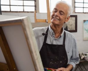 Senior man painting on a canvas