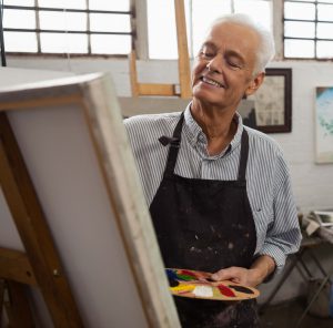 Senior man painting on a canvas