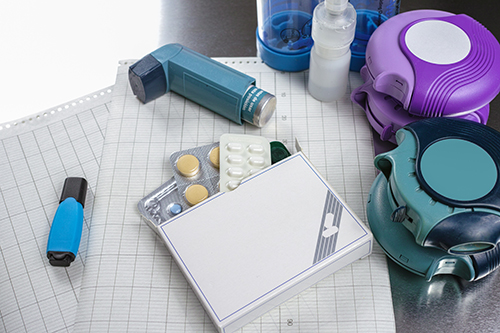 Asthma, allergy, illness relief concept, salbutamol inhalers, aerosol medication, drugs and paper on chrome background
