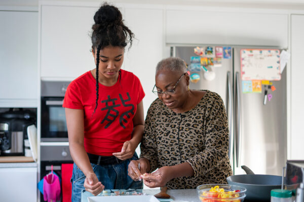Woman and teenage girl preparing meal in kitchen Woman and teenage girl preparing meal in kitchen