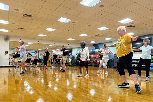 An exercise class of older adults in a gym