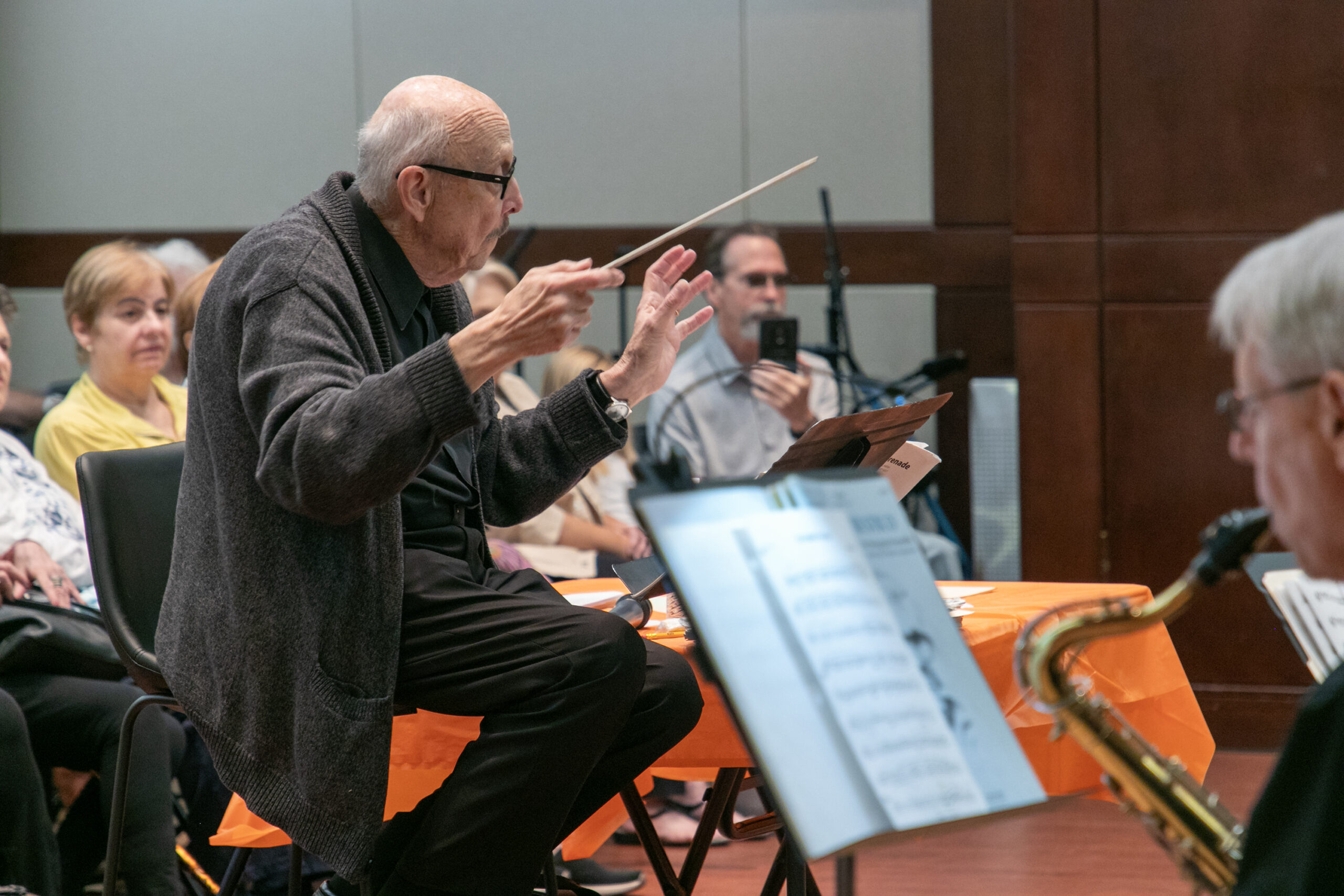 A composer leading a band on a stage