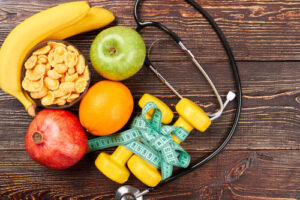 Healthy-Life (1) banana, apple, orange, and exercise equipment on a wooden table